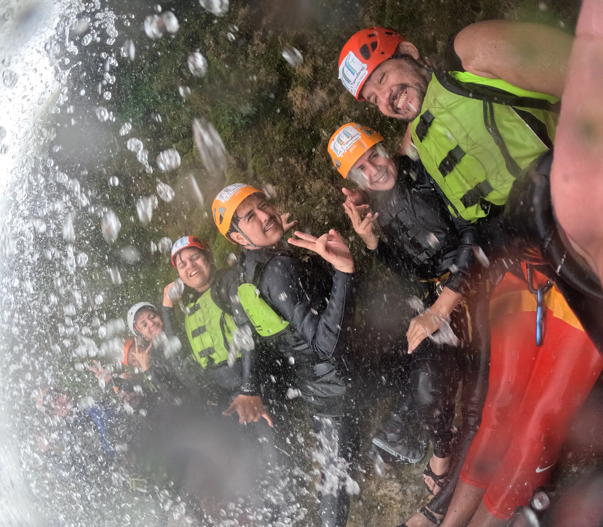 Grupo disfrutando bajo una cascada en Las 3 Tzimoleras